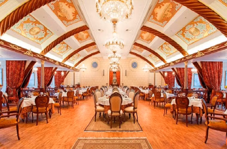 Phòng ăn sang trọng với mái vòm gỗ thiết kế theo lối kiến trúc dân gian Nga pha trộn với phong cách hiện đại tạo nên vẻ cổ kính sang trọng.