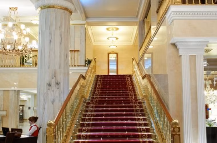 Cầu thang gỗ mạ vàng trải thảm đỏ lộng lẫy giống như cung điện Nga.