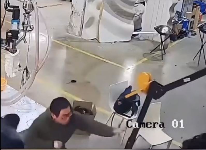 Cuối cùng, người kỹ sư đeo kính thận trọng vòng ra phía sau con robot, kéo cánh tay bị treo của nó lên, rồi ngắt nguồn điện mới làm con robot bình tĩnh lại.