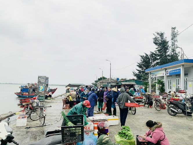 Những mối buôn xếp hàng đợi tàu vào để thu mua cá, họ chuẩn bị những vật dụng dùng để trữ cá..