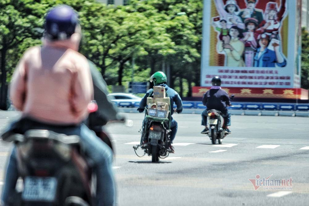 Tuy nhiên, ghi nhận của VietNamNet trưa nay cho thấy, không phải ai cũng có điều kiện tránh nắng. Tại nhiều địa điểm trên địa bàn Hà Nội, người lao động, công nhân môi trường, lực lượng làm nhiệm vụ đảm bảo an toàn giao thông vẫn phơi mình trong cái nắng nóng bỏng rát. Ảnh: Người dân ra đường mặc nhiều lớp áp để chống chọi với nắng hầm hập