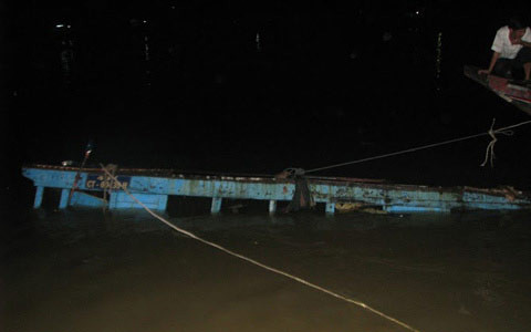 Chiếc tàu hàng chục tấn chỉ còn thấy nóc trên mặt nước (Ảnh: Phunuonline).