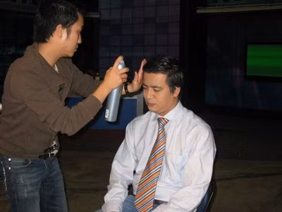 BTV Quang Minh đang được các chuyên gia chăm sóc tóc tạo hình bóng bảy.