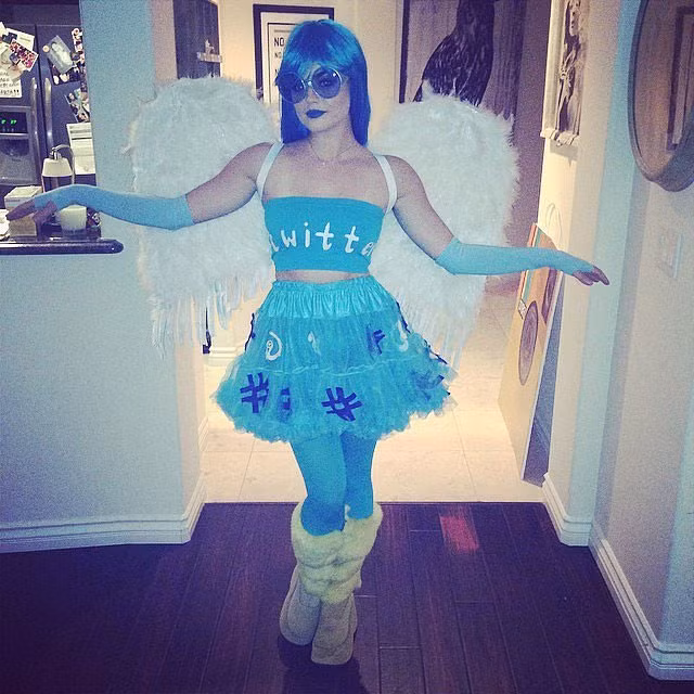 Lucy Hale mặc bộ váy xanh, đi tất xanh và tô son xanh, đeo đôi cánh trắng để "biến hình" thành một chú chim.