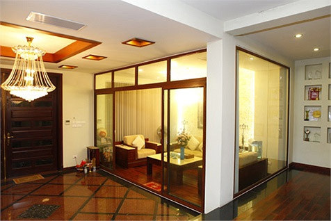 Phòng khách được bài trí đơn giản nhưng không kém phần sang trọng Chiếc đèn chùm pha lê tinh xảo là điểm nhấn của phòng.