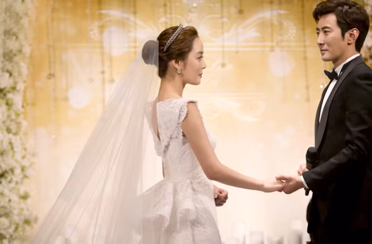 Trong buổi tiệc diễn ra sau đó, nữ diễn viên sinh năm 1979 mặc chiếc váy cưới màu trắng, tóc búi cao kiểu cổ điển, voan dài quết đất.