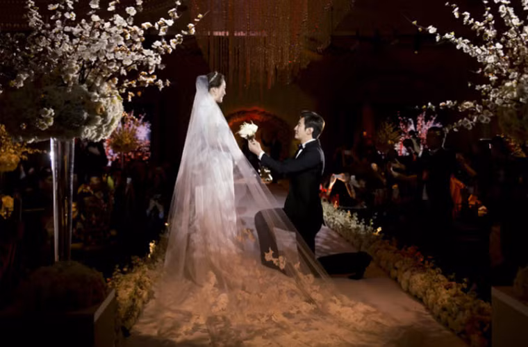 Chú rể Cao Tử Kỳ quỳ gối trao hoa cho cô dâu.