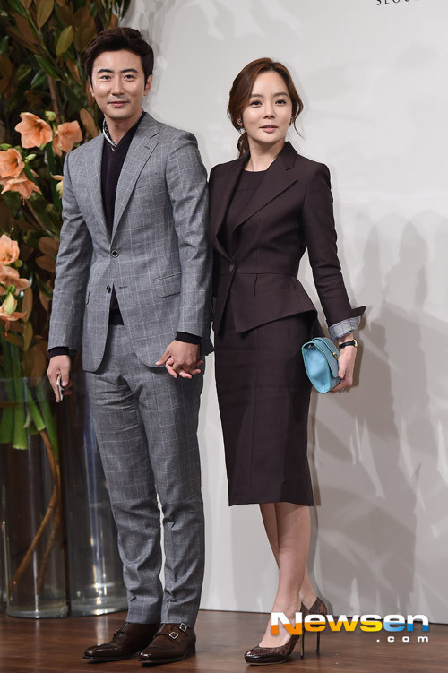 Hai vợ chồng nắm chặt tay nhau khi bước vào hội trường.