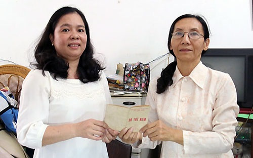 Bà Lê Thị Bích Thủy (bên phải) hiến tặng sổ tiết kiệm cho đại diện Bảo tàng TP HCM. Ảnh: Tuổi Trẻ.