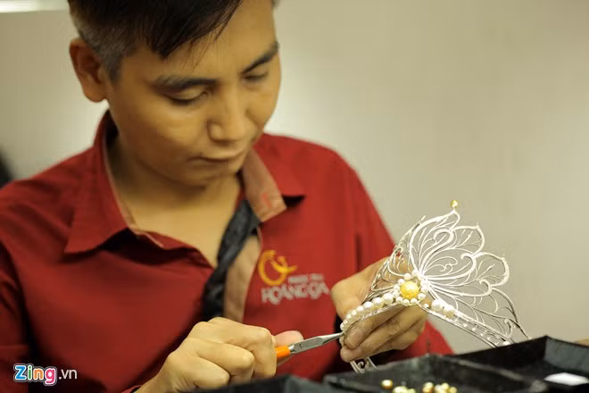 Người thợ cẩn thận đính từng viên ngọc trai. Đây là công đoạn quan trọng nhất vì mỗi viên có hình dạng khác nhau, mỗi vị trí lại cần những viên ngọc có kích thước, hình dáng khác nhau để tạo lên sự hài hòa, hoàn hảo cho vương miện.