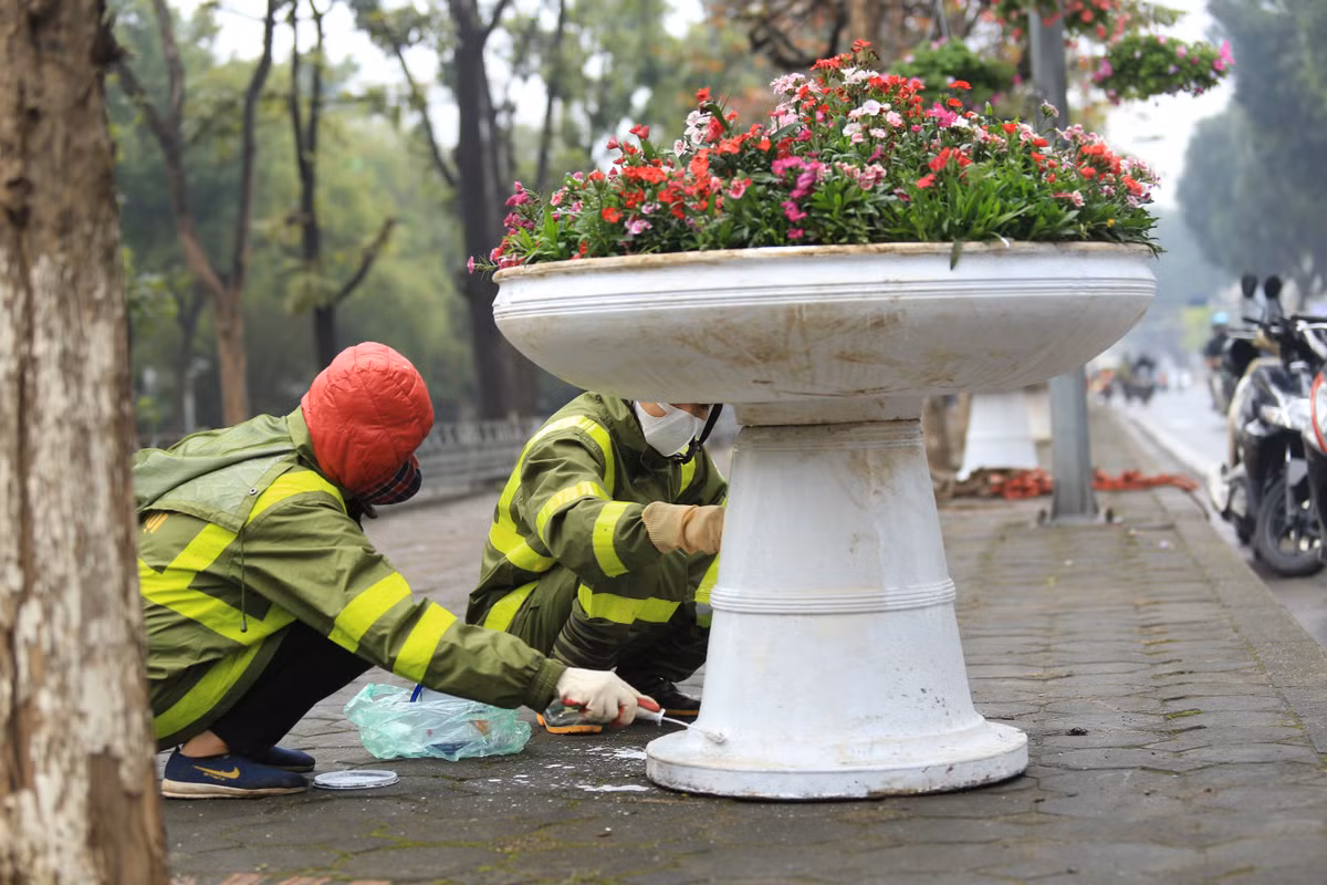 Các công nhân dầm mưa tân trang lại phố Kim Mã.