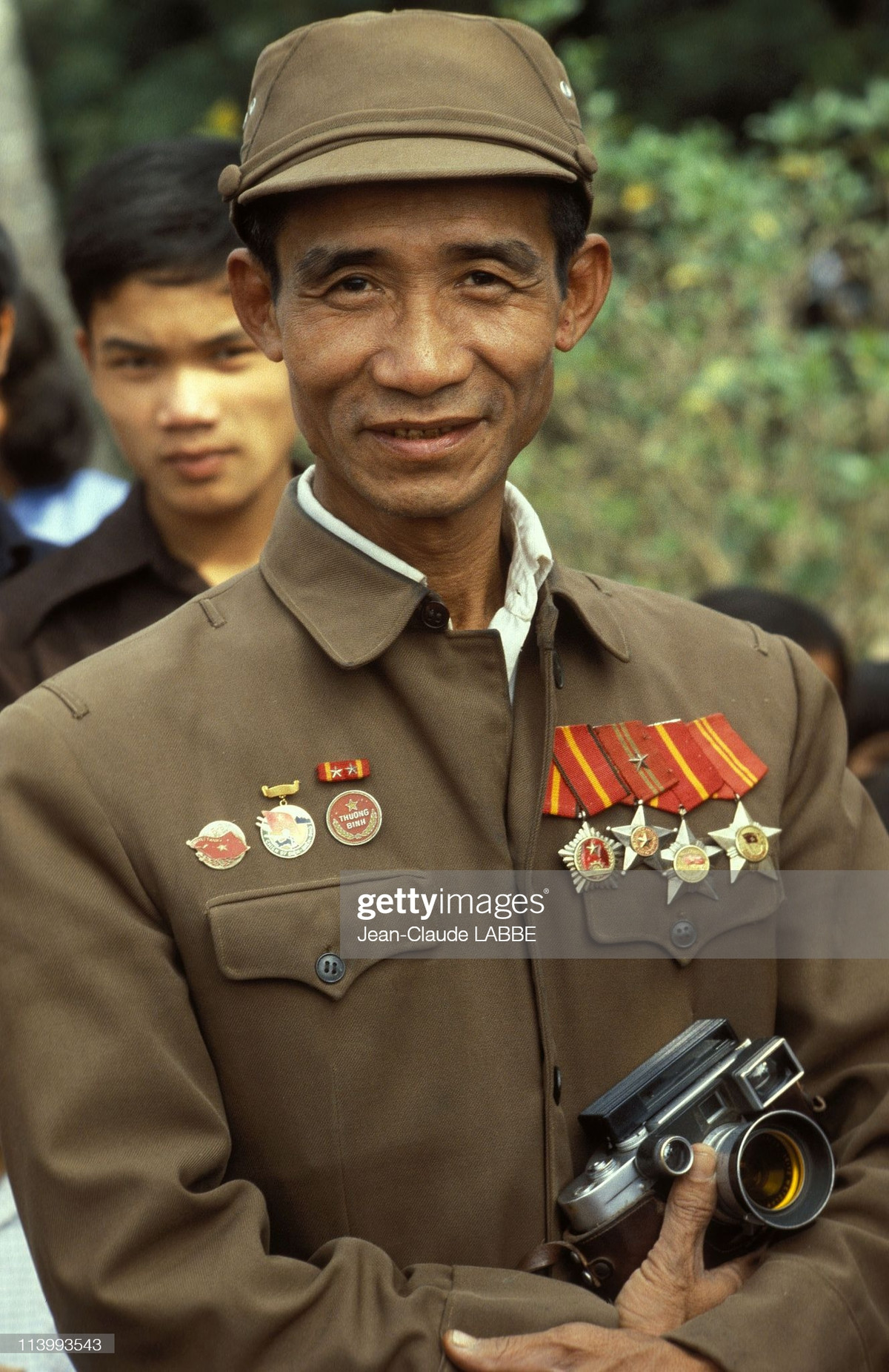 Người cựu chiến binh Hà Nội cầm chiếc máy ảnh Leica tại một buổi lễ kỷ niệm của Quân đội Nhân dân Việt Nam.