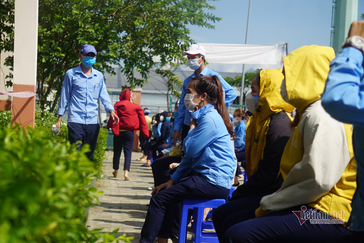 Được biết, đến 11h cùng ngày, công ty này đã ghi nhận 15 ca dương tính nCoV. (Công nhân dùng áo khoác che nắng chờ đến lượt lấy mẫu)