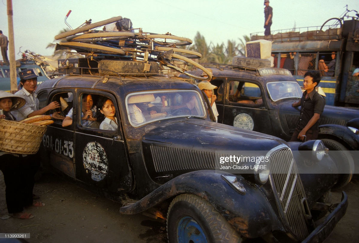Khung cảnh tại một bến xe ở TP HCM. Chiếc xe cũ của Pháp chở đầy khách và hàng hóa, đang hoạt động trong một hợp tác xã vận tải, năm 1994.