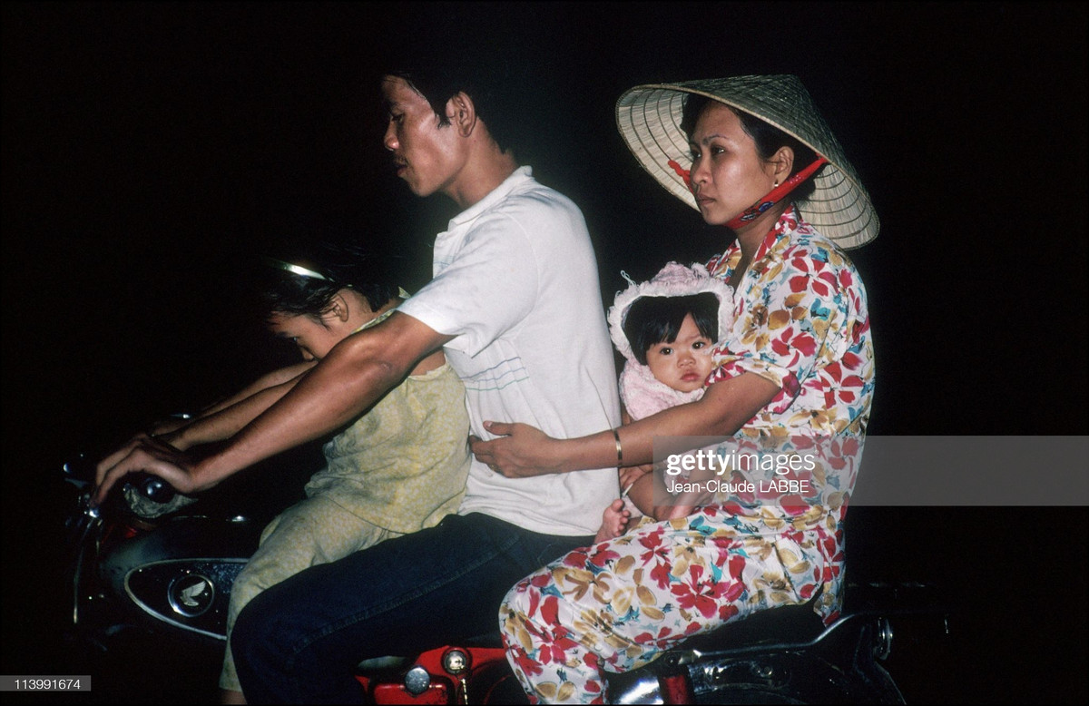 Một gia đình vi vu trên xe máy vào buổi tối ngày thứ Bảy, TP. HCM năm 1991. Ảnh: Jean-Claude Labbe/ Getty Images.