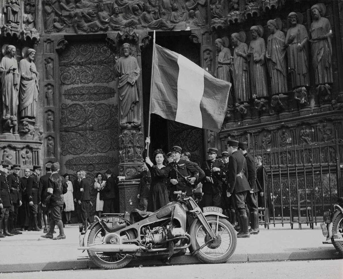 Cô gái Pháp vẫy quốc kỳ Pháp khi các lực lượng đã giải phóng diễu hành qua nhà thờ Đức Bà ở Paris, Pháp, ngày 26/8/1944. Nguồn ảnh: Thủy quân lục chiến Mỹ.