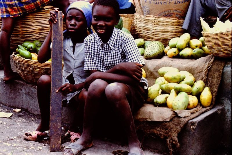 Hai chú bé bên các sọt hoa quả.