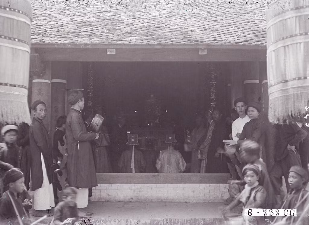 Cận cảnh một buổi lễ ở Văn Miếu Hà Nội thập niên 1920. Các vị chức sắc áo mũ chỉnh tề đang khấn vài trước một bàn thờ.