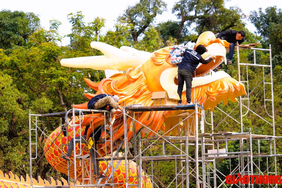 Đội ngũ nhân công đang trong quá trình hoàn thiện trang trí phần miệng rồng và đầu linh vật rồng.