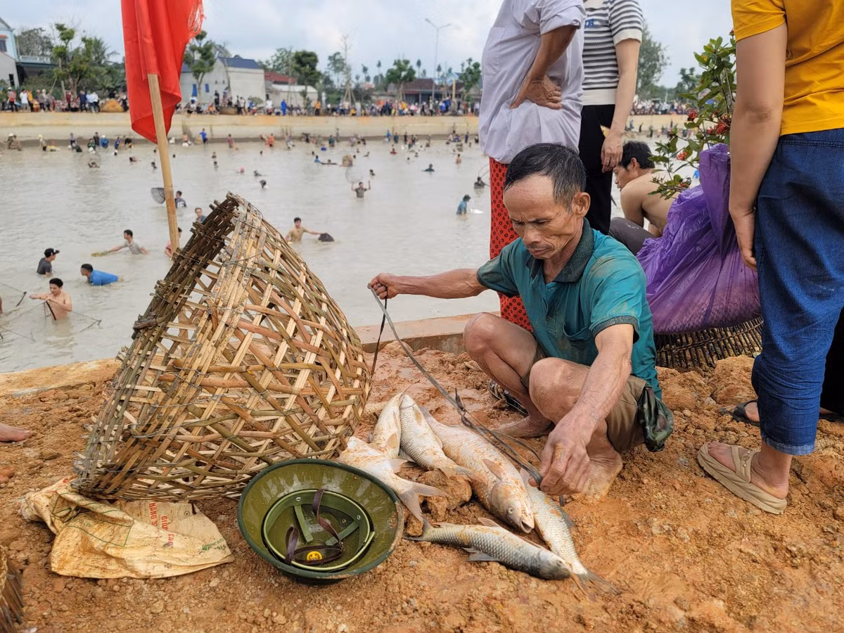 Cụ ông dùng dây để xâu cá bắt được.