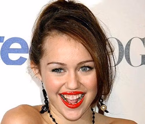 Màu son đỏ chót lem vào răng khiến Miley Cyrus trông kém xinh.