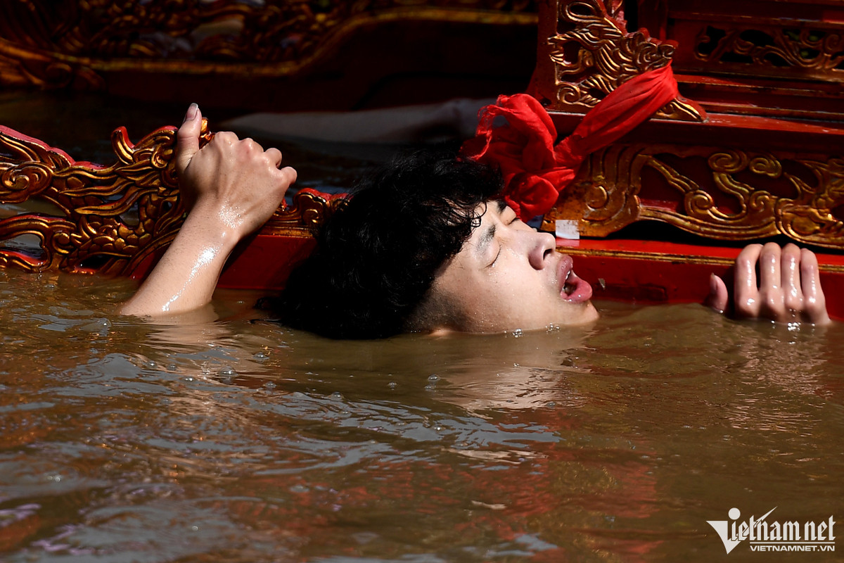 Chịu ngâm mình dưới sông khoảng 20 phút, các chàng trai khênh kiệu nhiều lần tỏ ra bị ngộp thở và mỏi gối, chùn chân.