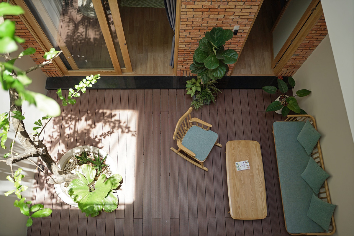 Nội thất trong nhà chủ yếu được làm bằng gỗ sồi, công năng đáp ứng vừa đủ những nhu cầu sử dụng cần thiết nhất. Mảng tường gạch thẻ ngoài tác dụng là điểm nhấn cho khoảng thông tầng ra thì còn có tác dụng làm dịu bớt độ chói sáng của khoảng giếng trời trên mái khi nắng chiếu xuống vào những khung giờ nắng gắt. Đây là không gian kiến trúc sư thích nhất khi ngôi nhà hoàn thiện xong, gia chủ có thể ngồi ở đây đọc sách và ngắm nhìn những tia nắng chuyển động theo từng khung giờ khác nhau.