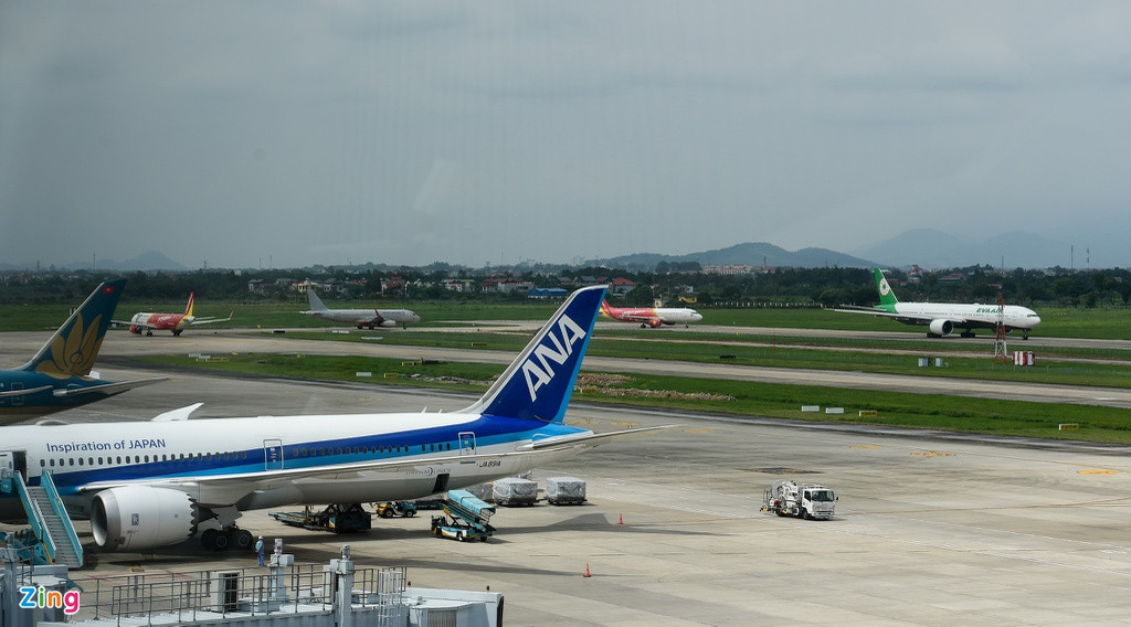 Trên đường lăn, máy bay tuyến nội địa nối đuôi nhau chờ đến lượt cất cánh. Việc nâng cấp một đường băng vẫn đang được thực hiện khẩn trương.