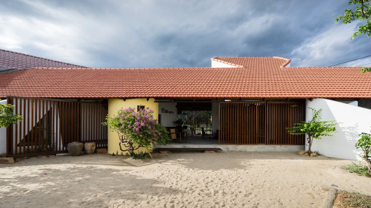 Các cánh cửa sử dụng hệ cửa lùa, khu vực sân trong không được trải bê tông hay gạch lát mà là một tấm thảm cát như một bãi biển thu nhỏ. Bãi cát này sẽ là nơi cho những đứa trẻ chơi đùa.