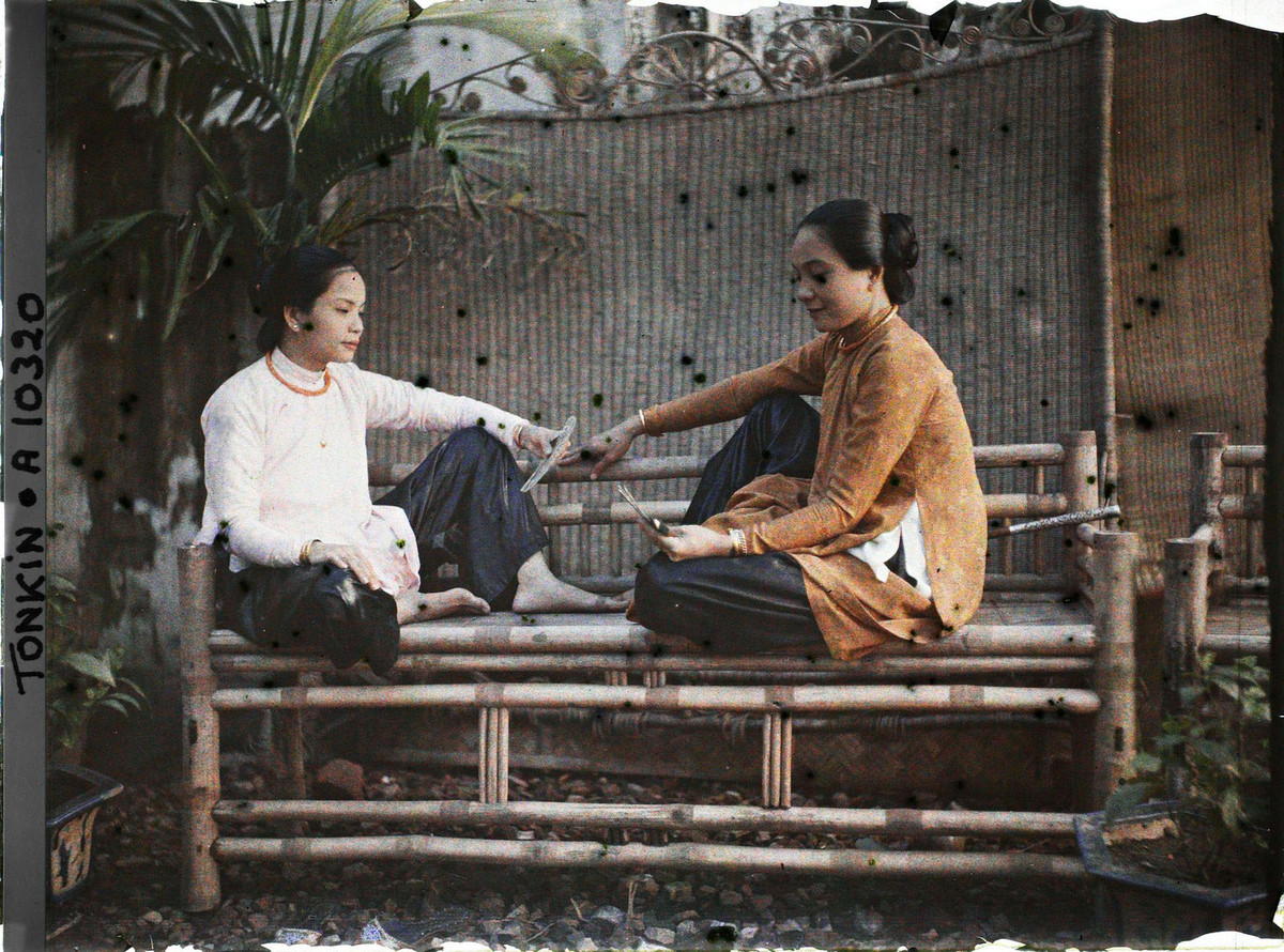 Hai người đẹp Sài Gòn ngồi chơi bài trên ghế tre.