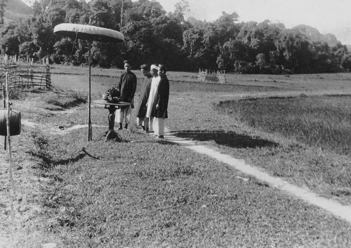 Những người đàn ông mặc lễ phục đứng bên bàn đặt lễ vật ở Tân Lý, Quảng Bình.