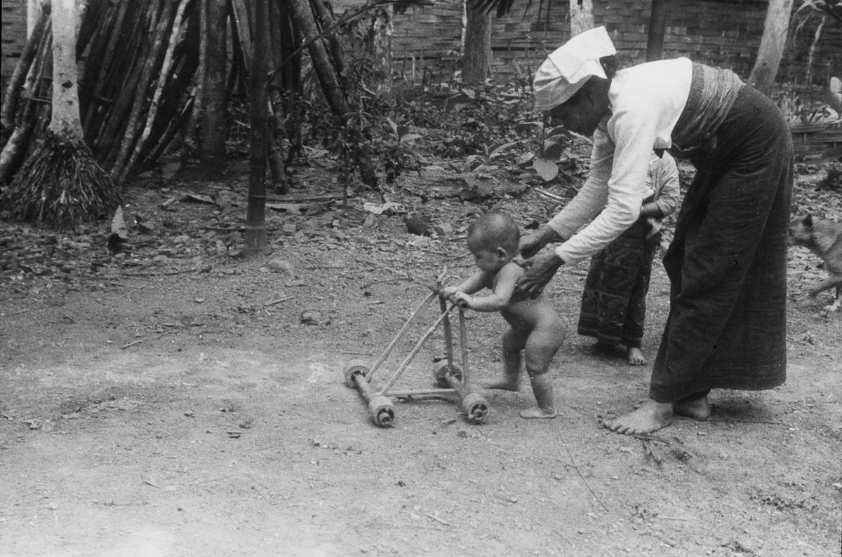 Bà mẹ người Mường đỡ con tập đi tại một bản ở Thanh Hóa.