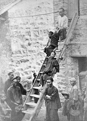 Một nhóm người dân Trung Quốc bao gồm cả nam giới, phụ nữ và trẻ em đứng cạnh bậc thang cao.