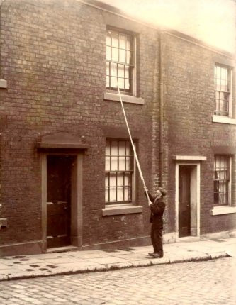 Trước khi phát minh ra đồng hồ báo thức, người gõ cửa được sử dụng để đánh thức mọi người dậy. Theo đó, người này sẽ dùng chiếc gậy gõ vào cửa sổ phòng người đó cho đến khi người được gọi thức giấc.