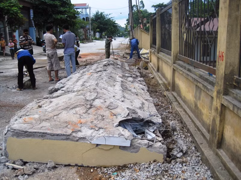 Nguyên cả mái cổng trường đổ sập đè nát chiếc xe.