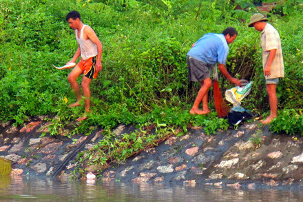 Để vớt được những con cá chết, người dân bơi ra giữa dòng mà không có phao.