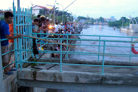 Người dân cố chen sát cửa điều tiết, nguy cơ rơi xuống rất cao.