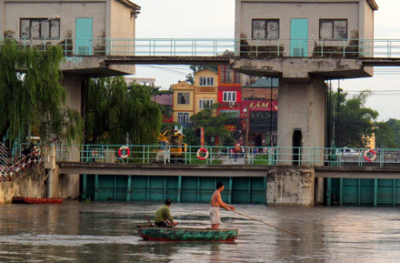 Giữa dòng xoáy và chảy mạnh, hai người đàn ông ngồi vẫn mải mê dùng điện ắcquy đánh cá, bất chấp lời kêu gọi của nhân viên quản lý cửa điều tiết.