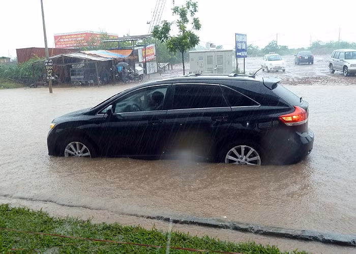 Mưa lớn, nước ngập sâu khiến không ít xe hơi chết máy, nằm ngâm mình trong nước chờ cứu hộ.