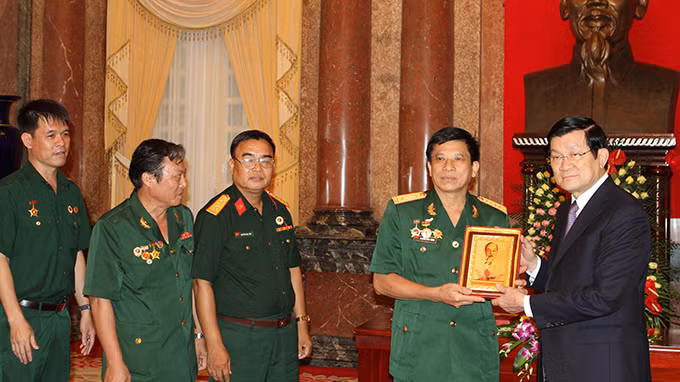 Chủ tịch nước Trương Tấn Sang tặng quà lưu niệm cho các cựu chiến binh. Ảnh: Võ Văn Thành.