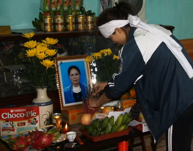 Con gái chị Đào Thị Sao bên di ảnh mẹ