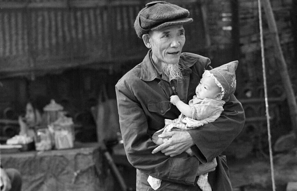 Người ông bế cháu nhỏ tại một khu chợ, 5/4/1973.