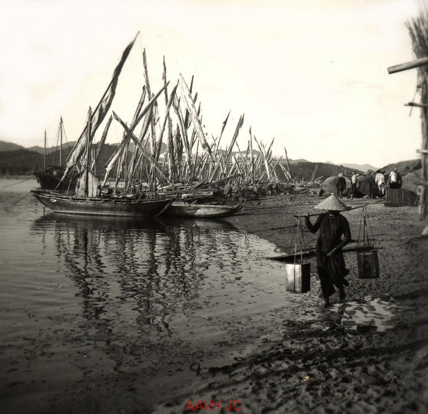 Người phụ nữ gánh nước trên bãi biển.