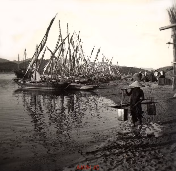 Người phụ nữ gánh nước trên bãi biển.