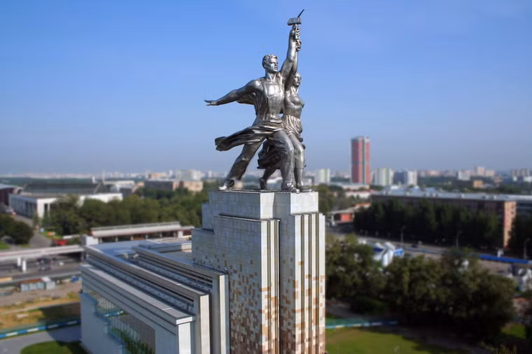 Bức tượng được tạo hình theo lối tả thực với một nam công nhân dáng vóc lực lưỡng, tay cầm búa giơ lên cao, đứng bên cạnh một nữ nông trang viên khỏe khoắn, tay cầm chiếc liềm cong sát cùng chiếc búa trên không. Hai người ở tư thế cùng bước lên phía trước, một tay đánh ra phía sau. Các hình tượng được trau chuốt đến từng chi tiết như thật với một kỹ thuật điêu khắc hoàn hảo trong việc thể hiện hình khối.