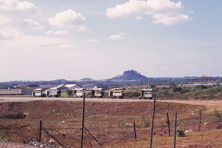 Đoàn xe lam trên xa lộ Biên Hòa, phía xa là núi Châu Thới.