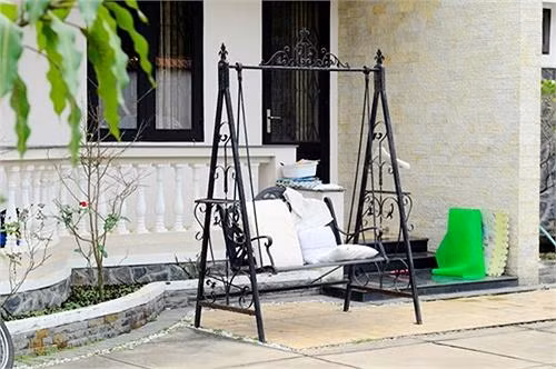 Ngôi nhà nằm nhỏ gọn giữa một không gian vườn tược xanh tốt với nhiều loại hoa và cây ăn trái.