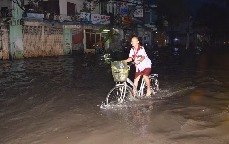 Các em học sinh sau giờ tan trường phải bì bõm lội qua biển nước
