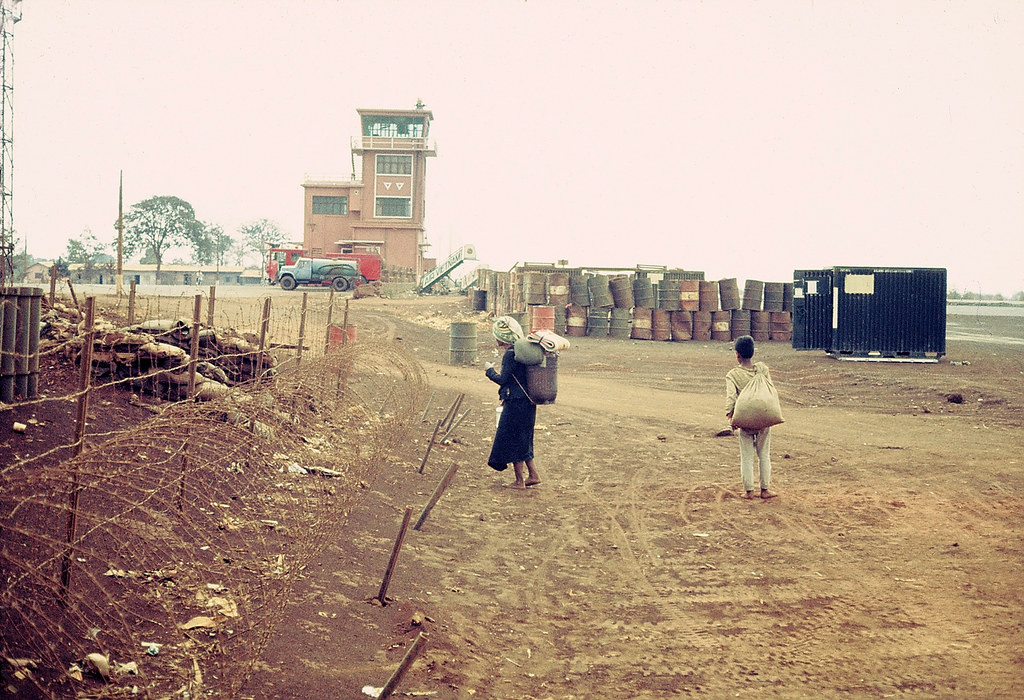 Lối vào phi trường Phụng Dực, khoảng năm 1968-1969. Do nằm ở quận hành chính Hòa Bình nên sân bay còn được gọi là phi trường Hòa Bình. Năm 1975, nơi đây đã xảy ra những trận đánh ác liệt trong chiến dịch giải phóng Buôn Ma Thuột. Vào ngày 17/3/1975, quân Giải phóng đã làm chủ được cứ điểm này.