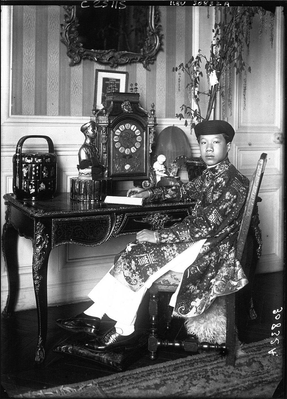 Bảo Đại - đã lên ngôi vua một năm - mặc trang phục truyền thống trong phòng học của mình tại Paris, 1926.